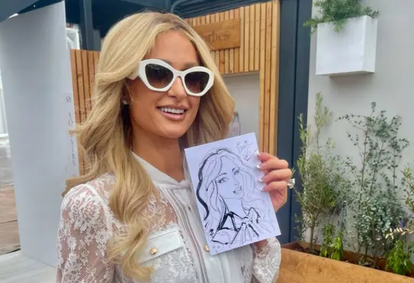 Paris Hilton holding her live portrait by Adriana Vita at Cannes Lions